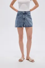 Short de denim azul con acabado acid wash y apliques de strass. Presenta tiro alto, diseño relaxed y bolsillos clásicos.
