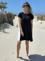 Vestido corto negro con panel lateral blanco, de corte holgado y mangas cortas con volados.