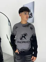 Sweater de tejido de punto con diseño bicolor en gris y negro, cuello redondo y estampado gráfico frontal con la marca Andreice.