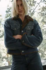 Cazadora de denim con interior y cuello de pelo sintético, manga larga, cierre frontal con botones y bolsillos con solapa en el pecho.