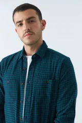 Camisa de viyela a cuadros negros, blancos y rojos, de corte slim fit, con bolsillos en el pecho, manga larga y cierre con botones.