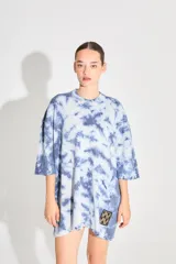 Sweater de punto tipo remerón oversize con diseño batik artesanal en tonos azul y blanco. Presenta silueta amplia, manga caída y etiqueta tejida con monograma en el frente.