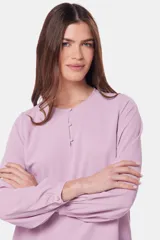 Blusa de manga larga con cuello redondo y cierre frontal parcial mediante botones forrados. Presenta diseño de doble capa en el frente y puños abotonados.