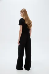 Pantalón negro de poliéster, con bolsillos laterales, tiro alto y diseño ancho.