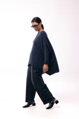 Sweater de punto con silueta amplia y relajada, cuello redondo y mangas largas con puños ajustados. Presenta un diseño de caída fluida y tejido suave.