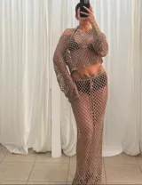 Conjunto de dos piezas de red color blanco, compuesto por un top de manga larga y una falda larga de tiro bajo con ajuste de cordón en la cintura.