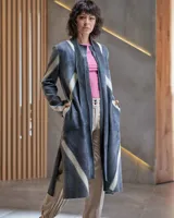 Tapado gris de lana merino afieltrada, con cuello que se prolonga a modo de cinto, aberturas y bolsillos laterales. Diseño artesanal teñido con técnica Tie Dye.