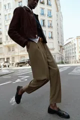 Pantalón de tiro alto con pinzas frontales, corte recto y bolsillos laterales. Incluye un cinturón a contraste con hebilla metálica.