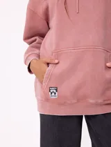 Canguro oversize color negro con efecto lavado, capucha y estampa gráfica en la espalda con tipografía desgastada y detalles en color turquesa.