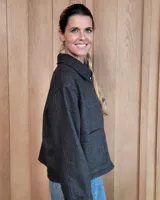 Chaqueta de textura bouclé en color bordó, con corte oversize, cuello camisero, cierre frontal y bolsillos laterales.