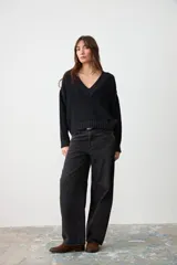 Sweater de punto texturizado color negro, con cuello en V acanalado, mangas largas y corte holgado con terminaciones en puños y ruedo acanalados.