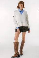 Sweater beige y azul con cuello en V y ribete bordeaux.