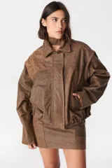 Campera de cuero estilo bomber con acabado desgastado, cuello clásico, cierre frontal oculto y mangas desmontables que permiten convertirla en chaleco.