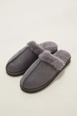 Pantuflas cerradas color marrón con ribetes de piel sintética en la abertura y suela plana.