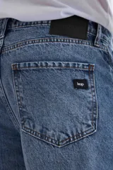 Pantalón jean celeste de corte mom, con tiro alto y tobillos ajustados.