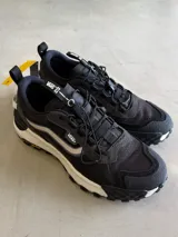 Championes Vans Crosspath XC, color negro, con detalles en gris claro y blanco. Diseñadas para uso todoterreno urbano, cuentan con parte superior de malla de PET reciclado, ante y textiles, tratamiento DWR, suela Vibram XS TREK EVO y entresuela UltraCush™.