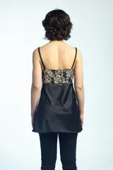 Musculosa de satén negro con inserciones de encaje beige con motivo floral en el escote y los laterales, tirantes finos y silueta acampanada.