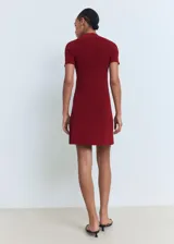 Vestido corto de punto fino color bordó, con cuello perkins, manga corta y silueta evasé.