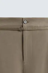 Pantalón de corte balloon fit en color gris, confeccionado en tejido con viscosa. Presenta pliegues frontales, cintura con cinturón integrado a contraste, bolsillos laterales y bolsillos traseros de vivo.