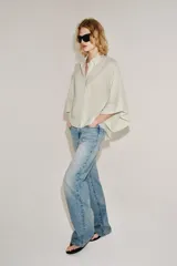 Camisa de mezcla de algodón de corte oversize y diseño asimétrico en tono azul, con cuello solapa, mangas tipo kimono por debajo del codo y cierre lateral con botones.