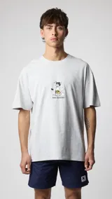 Camiseta Blue Banana modelo Wipeout, color gris melange, de corte oversize con mangas cortas y cuello redondo. Cuenta con un pequeño estampado frontal en el centro que representa a un surfista mareado cargando su tabla.