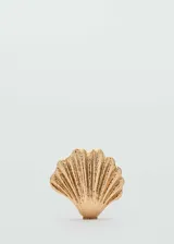 Bolso rígido tipo clutch con diseño de concha marina en color dorado. Cuenta con una textura rugosa que imita la superficie natural de una concha y cierre metálico. Incluye una cadena larga para llevar al hombro y forro interior.