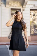 Vestido corto negro sin mangas, de corte recto y falda evasé.