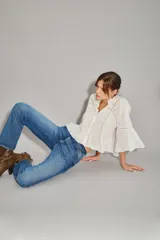 Jean de corte recto y tiro alto, confeccionado en denim azul con elastano. Presenta un lavado localizado con efecto de bigotes y torceduras, cierre frontal con botón y forrería estampada con logo.