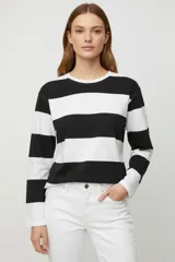 Buzo de manga larga con cuello redondo, confeccionado con un diseño de rayas horizontales anchas en color blanco y negro.