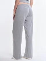 Pantalón de dormir de corte recto y holgado, confeccionado en tejido suave con textura acanalada. Presenta cintura elástica con cordón ajustable y bolsillos laterales.