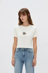 Remera cropped de algodón con cuello redondo, diseño holgado y estampado frontal de una copa con cerezas.