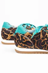 Championes de diseño artesanal con estampado animal print de leopardo. Presentan detalles en cuero color turquesa en la lengüeta, cordones, talón y collarín. Cuentan con una suela plana de goma color caramelo y una cuña interna oculta para mayor comodidad.