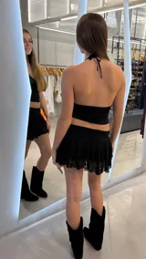 Minifalda short negra de encaje con volados y tiro bajo.