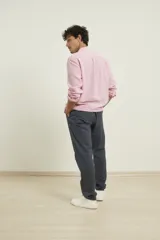 Camisa de lino color rosado, con cuello mao y cierre frontal parcial con botones. Presenta mangas largas y un bolsillo pequeño en el pecho.