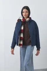 Campera acolchada de nylon color negro, con cuello alto, cierre frontal y botones a presión. Presenta un diseño de rombos y forro interior suave.