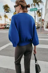 Jersey de punto liso color azul, con cuello redondo, botones delanteros y manga ancha por debajo del codo.