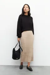 Falda larga de punto color negro, de corte ajustado al cuerpo, con diseño de costuras horizontales y diagonales que crean un efecto de paneles.