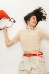 Cartera tipo shoulder bag tejida a mano con punto crochet en raffia color naranja. Tiene asa de cuero marrón y cierre superior con cremallera.