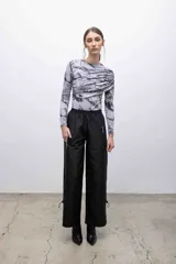 Pantalón negro de microfibra con corte recto y cintura elastizada. Cuenta con bolsillos frontales con cierre plateado, cordones ajustables en las pantorrillas y acabado repelente al agua.