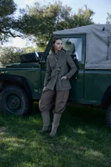 Chaqueta de lana en tono verde oliva con textura jaspeada, cuello mao y detalle de volado frontal. Presenta un corte entallado, bolsillos delanteros con solapa y cierre frontal con botones.