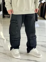 Pantalón de jean estilo cargo, color azul, de corte ancho y holgado, con múltiples bolsillos laterales en muslos y pantorrillas.