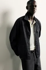 Sobrecamisa de corte relajado confeccionada en denim de algodón color azul oscuro. Presenta cuello solapa, manga larga, cierre frontal con botones y bolsillos plastrón en el delantero.