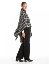 Ruana tejida con diseño de cuadros en blanco y negro, con borde ribeteado y cierre frontal tipo trenca con detalle de cuero sintético.