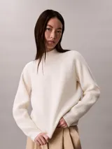 Sweater de punto Calvin Klein color blanco marfil, con diseño acanalado, cuello alto y mangas largas de corte raglán.