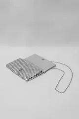 Bandolera pequeña de malla metálica en color cobre, con solapa frontal y cadena larga plateada para llevar al hombro o cruzada.