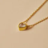 Gargantilla dorada con dije de corazón con circonia transparente.