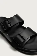 Sandalias negras de dos tiras anchas con hebillas ajustables y plantilla anatómica.