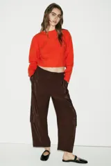 Pantalón de tiro medio con cintura elástica ajustable mediante cordón. Presenta un diseño de pernera holgada que se estrecha hacia el tobillo, con paneles laterales de tejido combinado y bolsillos cargo laterales.