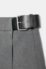 Falda pantalón de tiro medio en color gris, con diseño de tablas y cinturón integrado con hebilla metálica lateral.