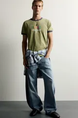 Jeans loose balloon fit de denim de algodón con diseño de cinco bolsillos y efecto lavado. Presentan bandas laterales en contraste y cierre frontal con cremallera y botón.